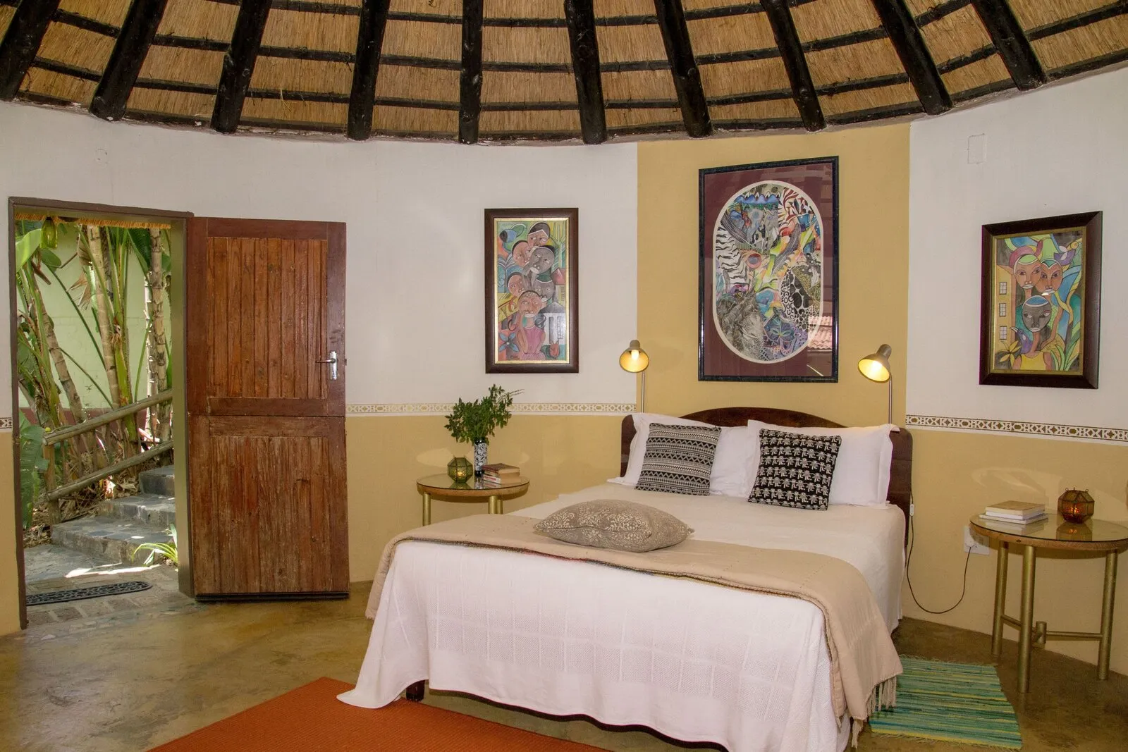 Rondavel bedroom with African art and private garden entrance